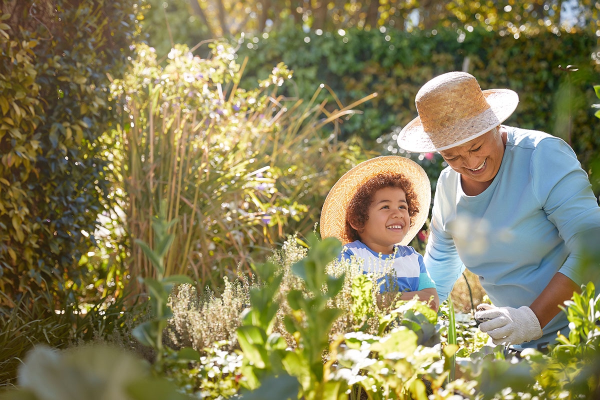 Retired Alberta educator enjoying quality time gardening with grandchild, supported by MyRetiree Plan health benefits.