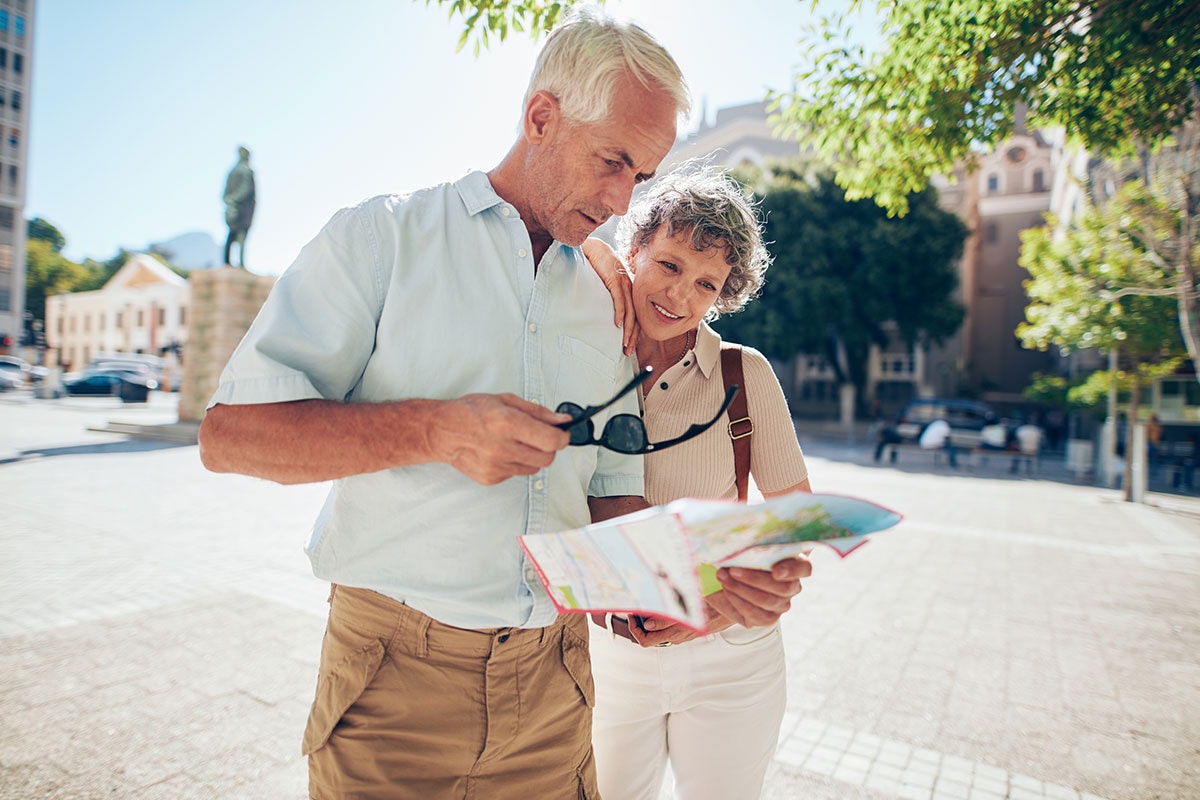 Senior couple navigating a city abroad using a tourist map during retirement travel