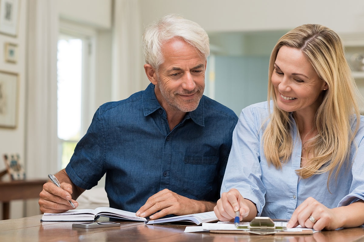 Retired couple reviewing MyRetiree Plan benefit change documents together at home in Alberta