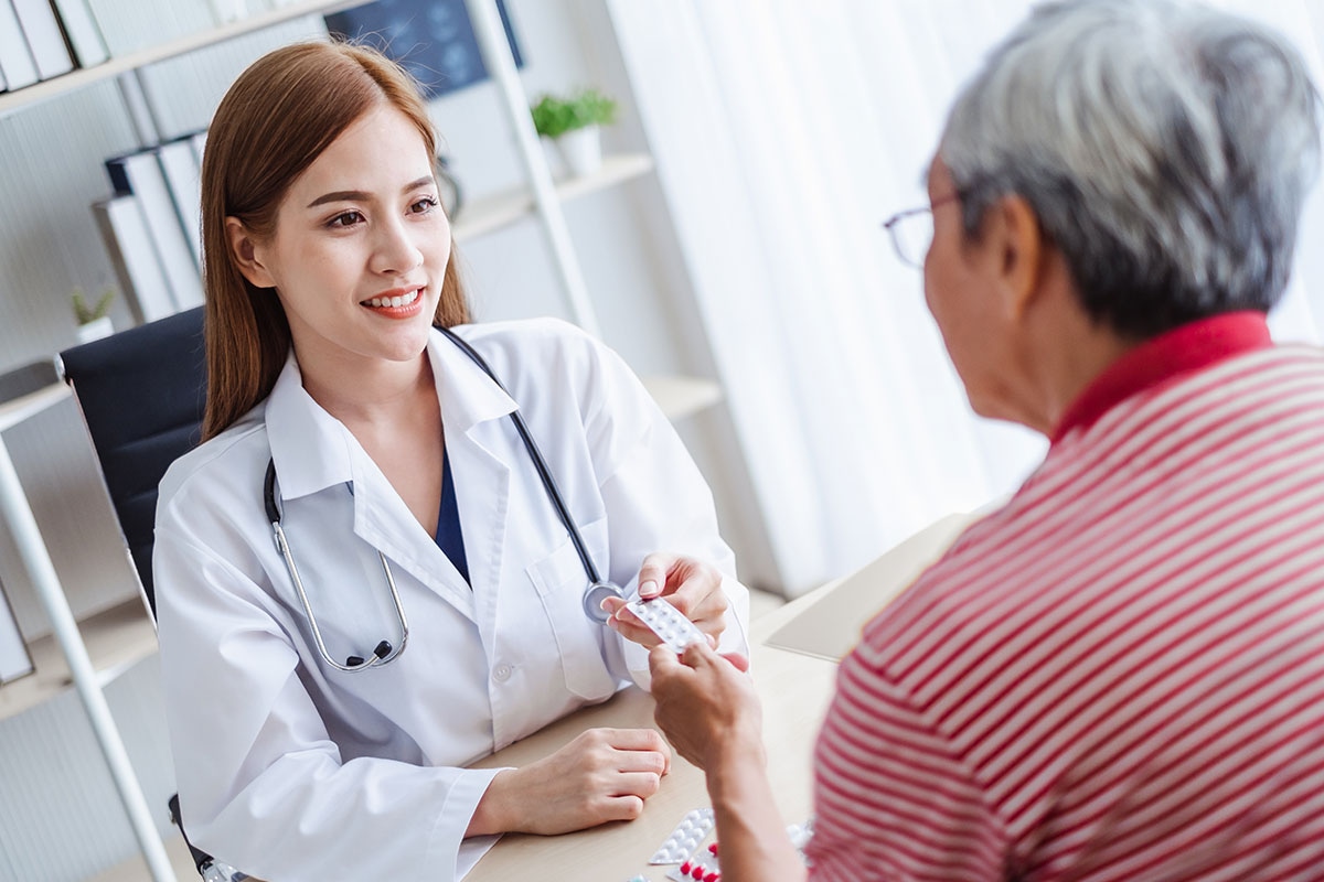 Healthcare provider guiding retired Alberta educator through first-line medication options for prescription drug plan