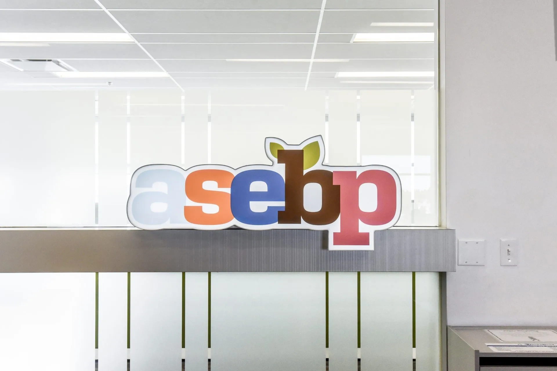 ASEBP logo sign at reception desk in Edmonton office, serving Alberta education employees since 1968